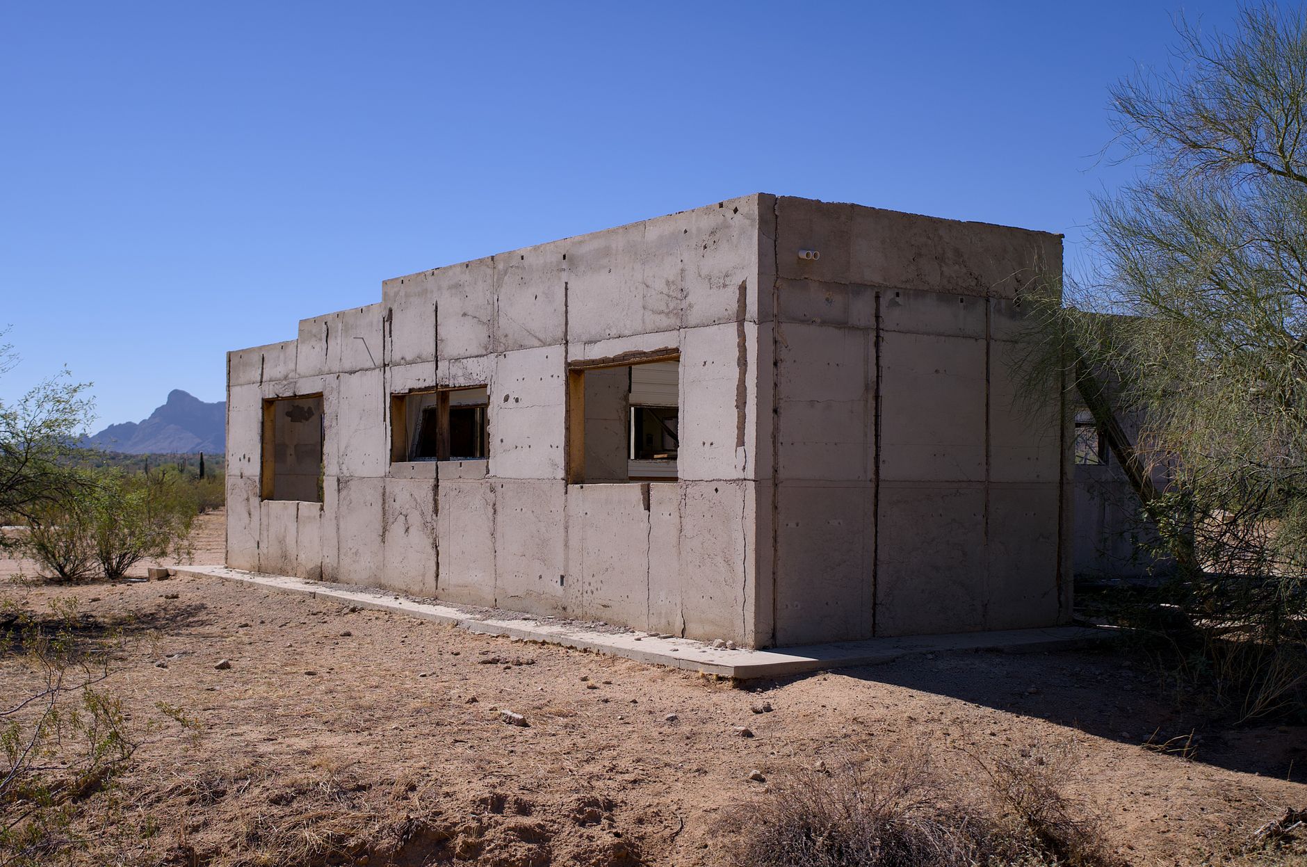 Minimalist rammed-earth structure in desert landscape